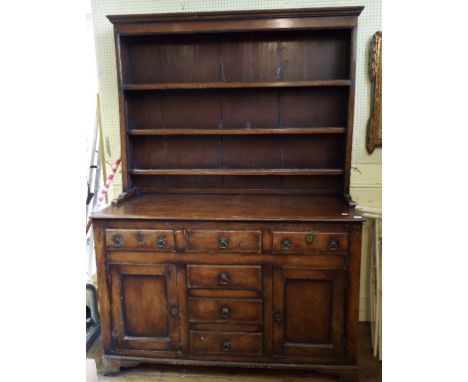 A pine kitchen dresser, the three tier pate rack above an arrangement of six drawers and a pair of panel doors, 147 cm wide
