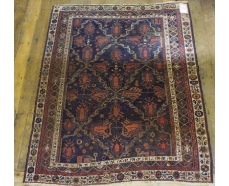 A Persian rug, decorated stylised motifs, on a blue ground, within a multi border, 165 x 136 cm