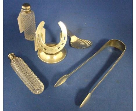 A silver novelty match striker, in the form of a horseshoe, London 1927, 7 cm high, a silver caddy spoon, a pair of silver su