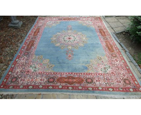 A Persian style carpet, with a central medallion, on a blue ground, within a multi border, 375 x 271 cm