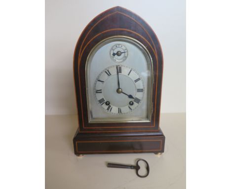 A mahogany and line inlaid lancet mantel clock, silvered dial, roman numerals to chapter ring - in working order 