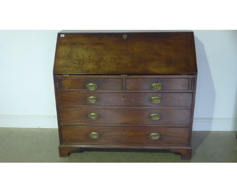 A Georgian Cuban Mahogany Bureau with a well fitted interior over two short and three long drawers on bracket feet, with a ni
