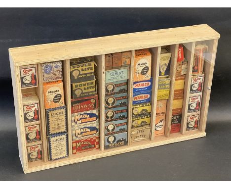 A collection of original lamp bulb packaging in a wooden display case including brands such as Osram, Royal Ediswan and Mazda