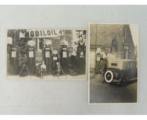 An early black and white postcard depicting a garage scene of four petrol pumps, all with globes, including a Dominion square
