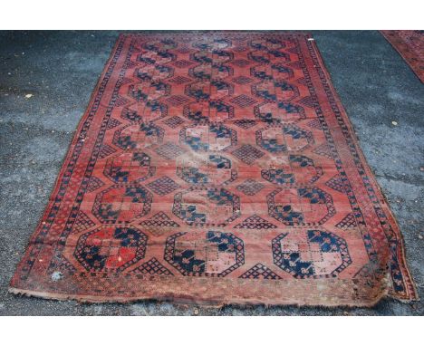 Bokhara carpet with three rows of nine guls over red ground and triple border, 447cm x 320cm. 