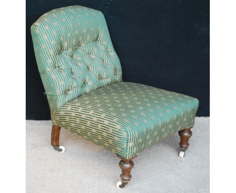 Victorian button-back nursing chair with stuff-over seat and raised on squat baluster turned legs terminating in ceramic cast