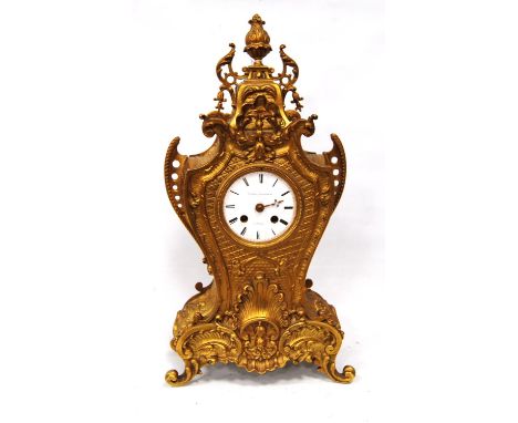 Gilt metal mantel clock by Promoli &amp; Hausburg, Paris, mounted by finial with scrolling brackets and floral and shell deco