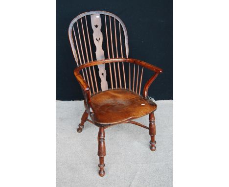 Yew and elm Windsor chair with comb back, pierced central splat, hoop arms, shaped seat and raised on splayed baluster turned