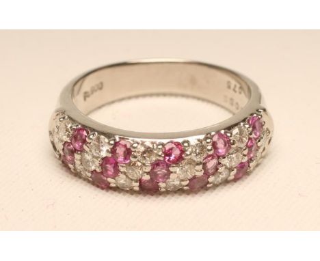 A RUBY AND DIAMOND HALF HOOP RING, pave set with a triple wrythen band of rubies and diamonds to a plain wide platinum shank,