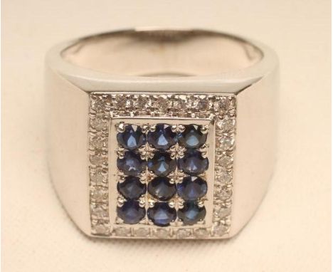 A GENTLEMAN'S SAPPHIRE AND DIAMOND RING, the chequer board panel set with twelve vivid blue small sapphires within a border o