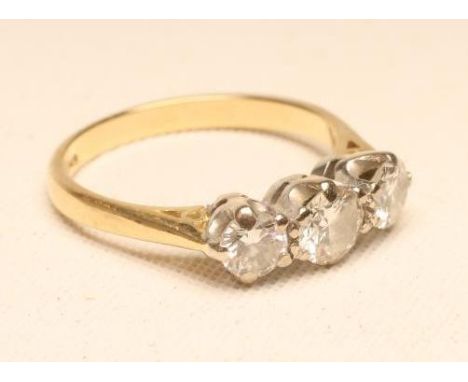 A THREE STONE DIAMOND RING, the central brilliant cut stone of approximately 0.4cts flanked by two similar smaller stones to 