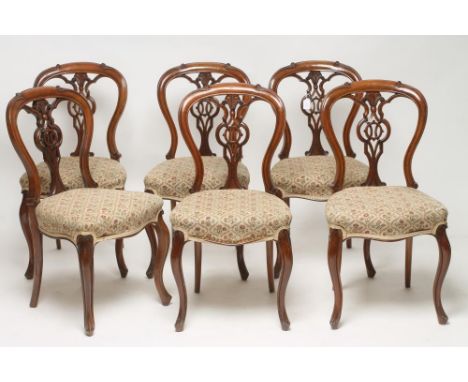 A SET OF SIX VICTORIAN WALNUT DINING CHAIRS of open spoonback form upholstered in ivory ground floral tapestry, the channelle