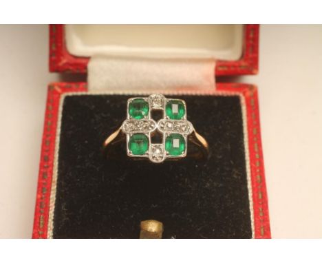 AN ART DECO EMERALD AND DIAMOND DRESS RING, the square panel open back collet set with four faceted emeralds and six pave set