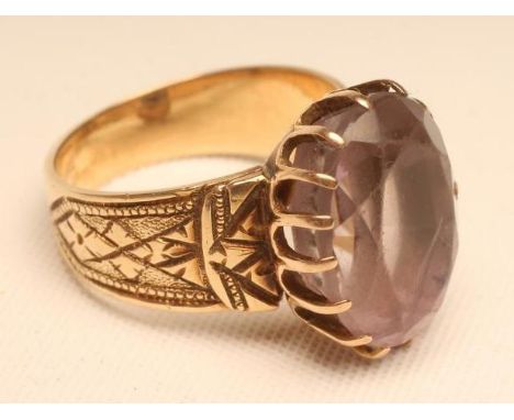 A VICTORIAN AMETHYST DRESS RING, the oval facet cut stone claw set to engraved shoulders and a gold shank, size M 1/2 (Est. p