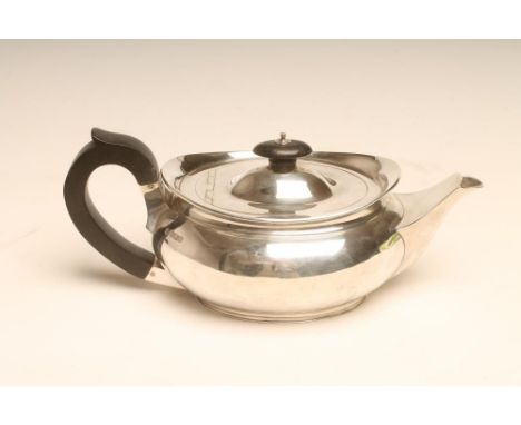 A BACHELOR'S SILVER TEAPOT, makers W & C Sissons, Sheffield 1913, of prow form, the flat hinged cover with ebony knop and com