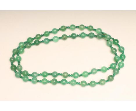 A SINGLE STRING OF AUSTRALIAN JADE BEADS, the fifty six faceted beads with facet cut emerald double bead spacers (Est. plus 1