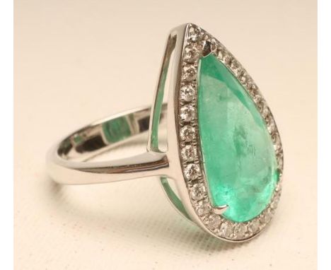 AN EMERALD AND DIAMOND COCKTAIL RING, the Colombian pear cut emerald of 5.29cts claw set to a border of small millegrain set 