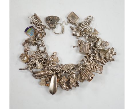 A 1970's silver charm bracelet, hung with assorted charms including birdcage, abacus, piglet, etc. and another silver charm b