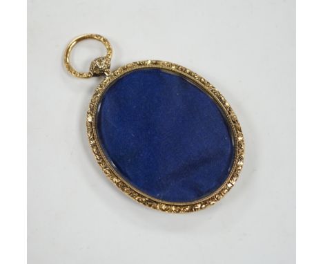 An engine turned yellow metal oval mourning locket, verso with small glazed oval panel, 56mm.