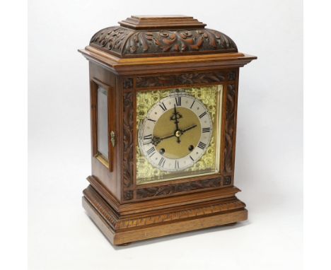 A carved walnut mantel clock with German movement, 36cm