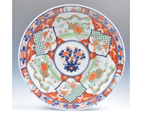 A Japanese Meiji period late 19th Century Imari charger plate having central white cartouche panel depicting a still life spr