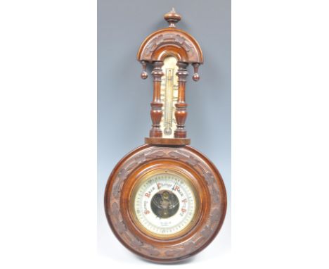 A 19th Century Victorian wall barometer having a walnut case. The central enamel dial being signed Youngs Ltd Exeter. Carved 