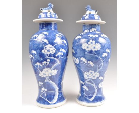 A pair of 19th Century Chinese blue and white porcelain vases and covers hand painted in the prunus pattern. The vases of bot