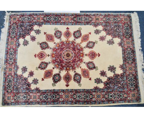 An early 20th Century Persian carpet rug having a white ground with geometric panels and medallions with tassel ends. Measure