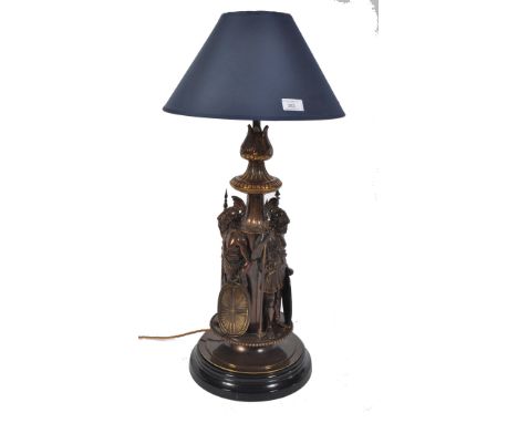 A large 20th century classical table lamp depicting gladiators in bronzework being raised on a polished slate worked socle ba