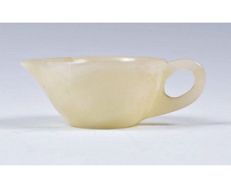 A 19th Century Chinese mutton fat jade jug having a shaped lip with simple hoop handle. Measures 3.5cm high by 9cm long.