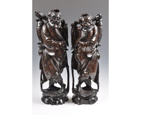 A pair of 19th Century Chinese hand carved hardwood statues figures depicting fisherman holding caught fish. The robes decora