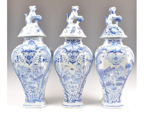 A set of three 18th / 19th Century Delft blue and white jars or vases and covers of wasted form raised on stepped octagonal b