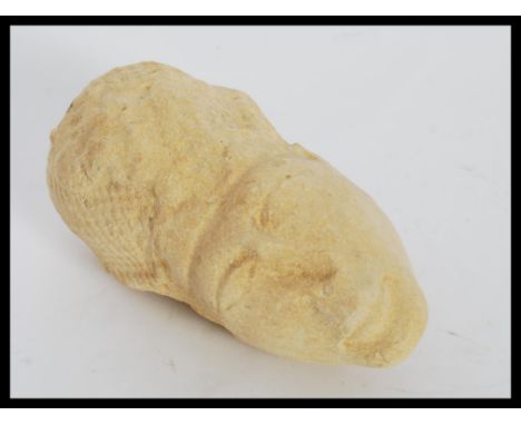 An Egyptian carved limestone Amana head having an elongated face and wearing a&nbsp;Khepresh war bonnet. Measures 16cm long.&