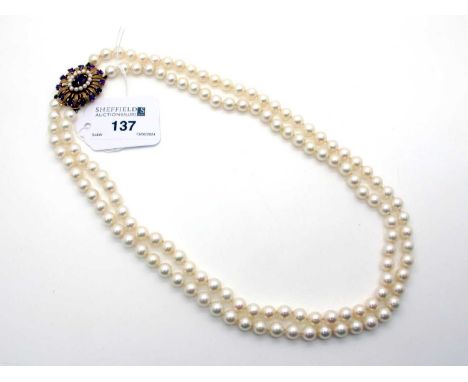 A Two Row Uniform Pearl Bead Necklace, knotted, to large oval amethyst and pearl cluster clasp, stamped "9ct", approximately 