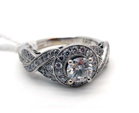 Neil Lane; A Modern Diamond Set Ring, brilliant cut four claw set to the centre within diamond set halo, between crossover sh
