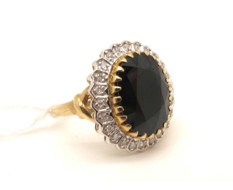 A Modern Large Sapphire and Diamond Oval Cluster Ring, claw set to the centre within illusion set border (finger size P).