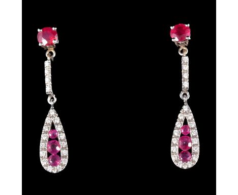 A pair of ruby and diamond earrings, each with three graduated brilliant cut rubies channel set to the centre of a pear shape