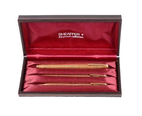 Sheaffer - an 18 carat yellow gold three piece pen and pencil set, London 1973, 1974, 1975, engine turned design, no personal