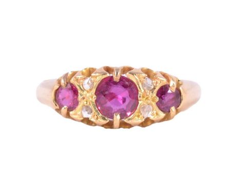 A ruby and diamond ring, the three graduated circular mixed cut rubies divided by two pairs of diamond chips, all claw set in