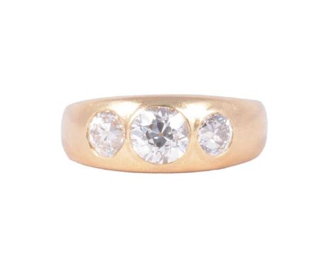 A Victorian diamond three stone gypsy set ring, the three old European cut stones rub over set in an 18 carat yellow gold tap