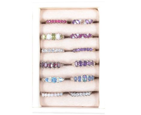 Twelve modern silver gemset half hoop rings, stones include white opal and opal triplets, amethyst, peridot, garnet, ruby, al