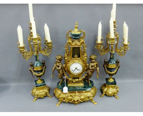 Green hardstone and gilt brass French style clock garniture comprising a clock with urn finial flanked by Cherubs on a shaped