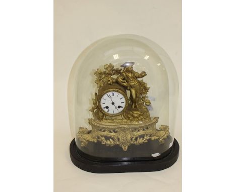 A late 19th Century gilt metal eight day mantle clock with a figure of boy in a hat complete with stand and dome