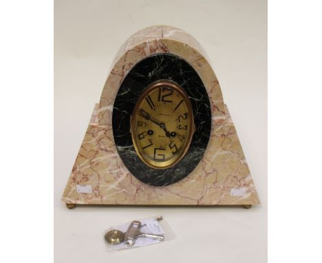 A stylish beige and black marble Art Deco mantel clock, the brass coloured oval dial is surrounded by a black oval insert, De