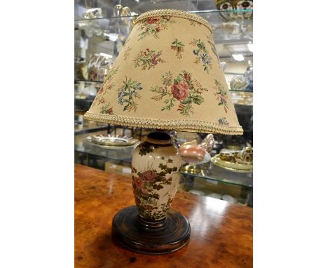 A Japanese Satsuma lamp base, with shade, painted florals with gilding detail, fitted on turned wooden base