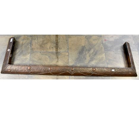 An Arts &amp; Crafts copper fire fender insert, hammered body decorated with scrolling flower motifs, circa 1900, 54" long ap