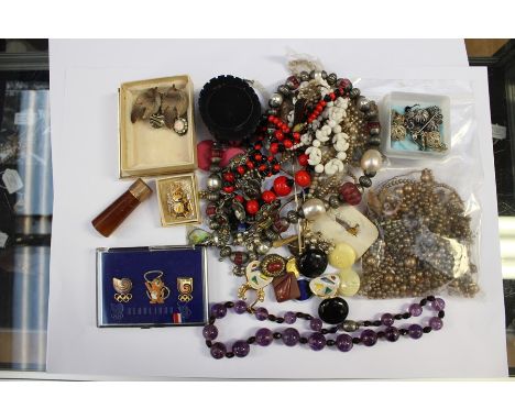 A collection of costume jewellery to include; Indian white metal jewellery, badges, 1988 Olympics parasol handle, agate, amet