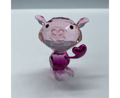 Crafted in red crystal, this little pig spreads love with fuchsia pant and clear crystal feet. The piece is finished with a h