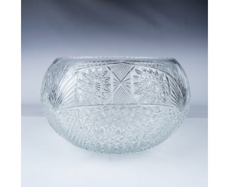 This elegant cut glass crystal bowl showcases an exquisite geometric pattern featuring starbursts, fans, and crosshatched tex
