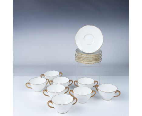 A beautiful set of 8 porcelain cups and 8 saucers, featuring delicate gold-trimmed rims and handles. The scalloped edges add 